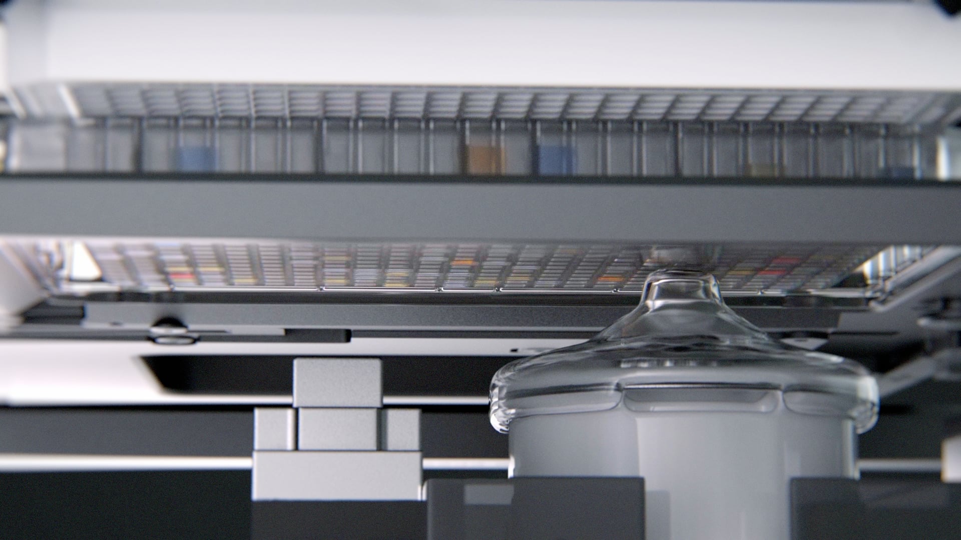 Acoustic droplet ejection transducer beneath microplate during contactless liquid transfer in automated laboratory equipment.