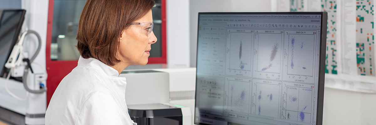 Woman looking into flow cytometry dot plots