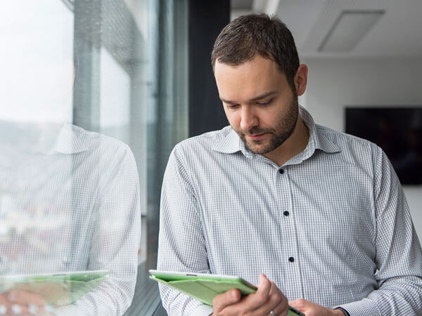 Man holding iPad by a window
