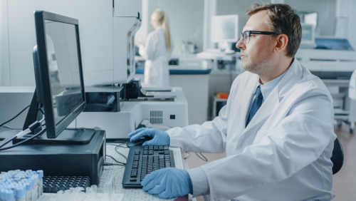 Male Research Scientist Sits at His Workplace in Laboratory.